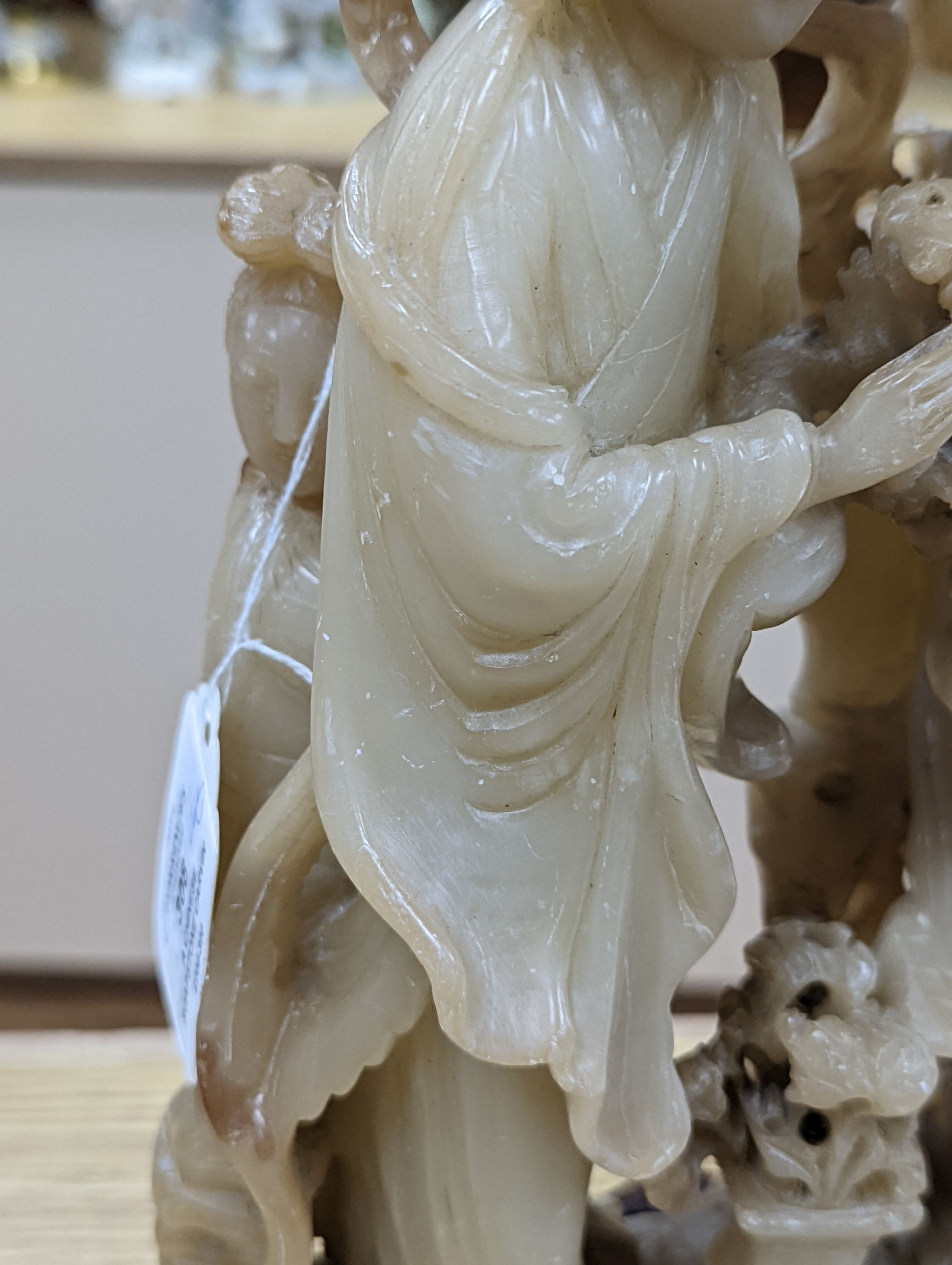 A Chinese soapstone carving of two ladies, wood stand, early 20th century, 36 cms high.